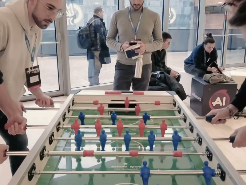 Attendees playing foosball in the AI Heroes networking area